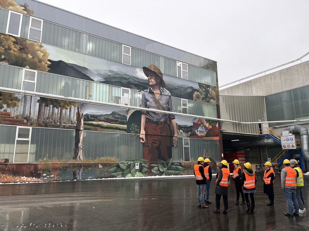 AK Nachhaltigkeit: „Die Wächterin des Waldes“ – Wandbild an einer Lagerhalle auf dem Werksgelände